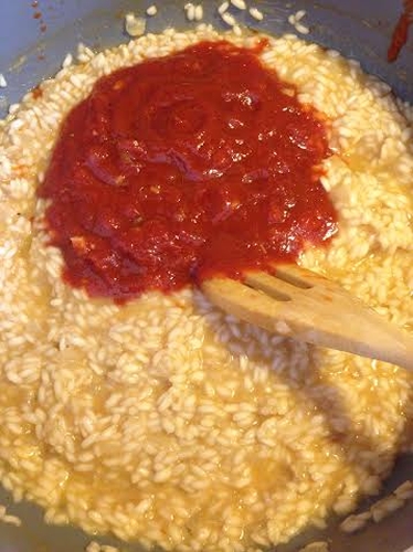 האורז מבושל כמעט עד הסוף עם רוטב העגבניות